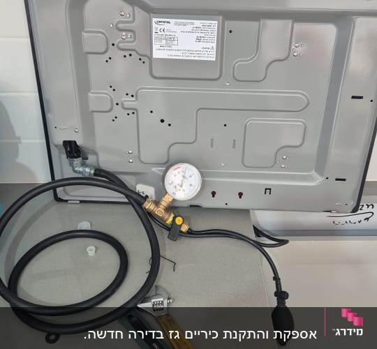 מד לחץ גז מחובר לצינור ליד כלי עבודה